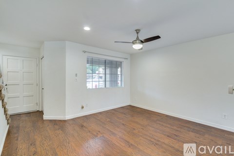 A room with wooden floors and a ceiling fan.