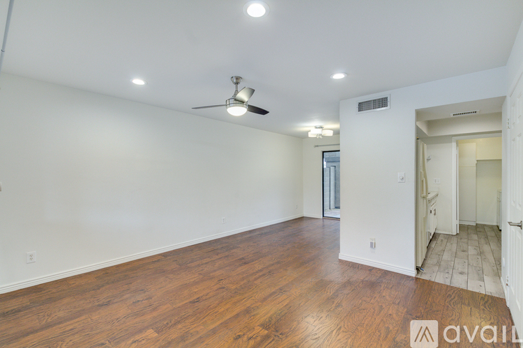 A room with wooden floors and a ceiling fan.