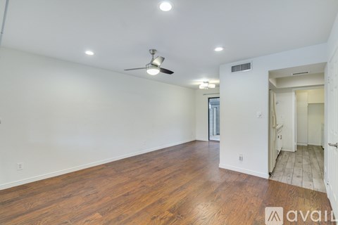A room with wooden floors and a ceiling fan.