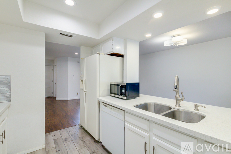A kitchen with white cabinets and a white fridge.