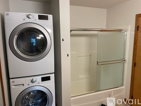 A stack of two washing machines in a laundry room.