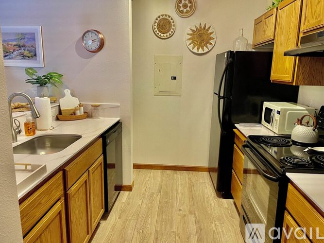 A kitchen with wooden cabinets and a black refrigerator.