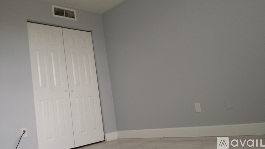 A room with a white door and a wall socket.