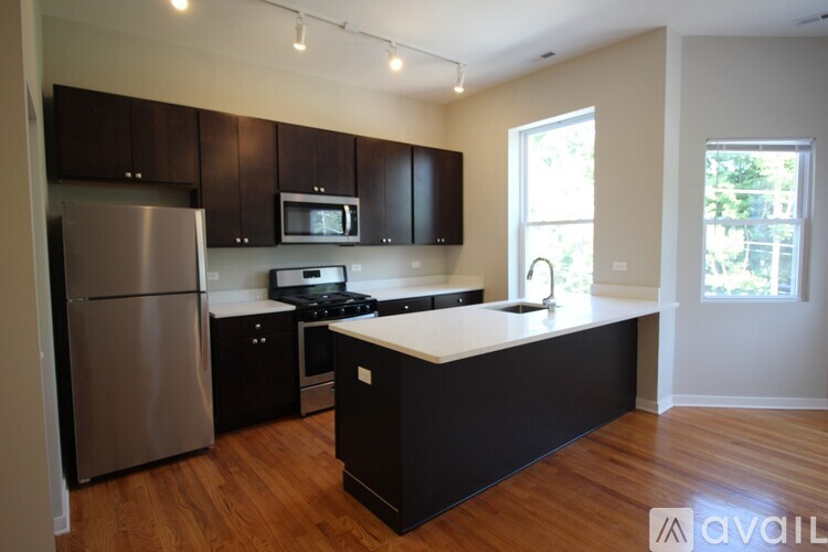 A kitchen with a refrigerator, microwave, and stove.