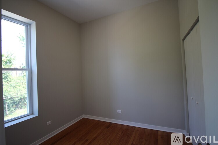 A room with a window and wooden flooring is available for rent.