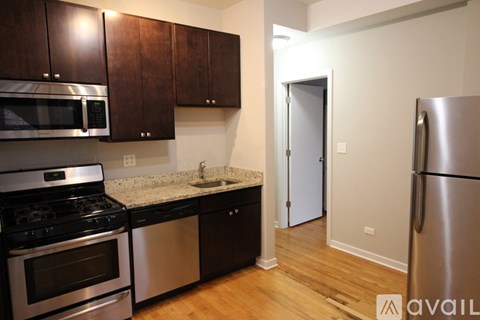 A kitchen with dark wood cabinets and stainless steel appliances.