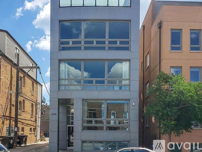 A modern building with a glass facade is situated between two other buildings.