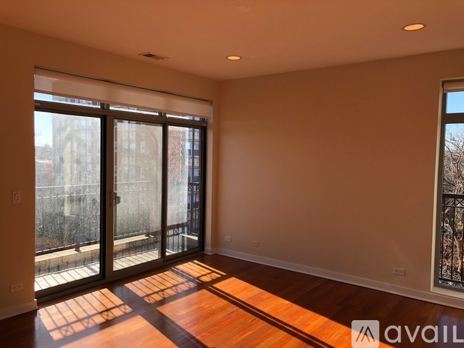 A room with wooden floors and a large window with a view of a cityscape.