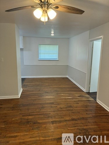 A room with wooden floors and a ceiling fan.