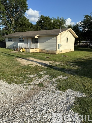 A house with a gravel driveway in front.