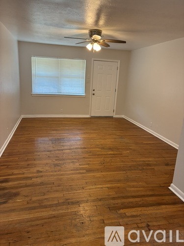 A room with wooden flooring and a ceiling fan.