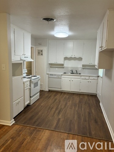 A kitchen with white cabinets and appliances.
