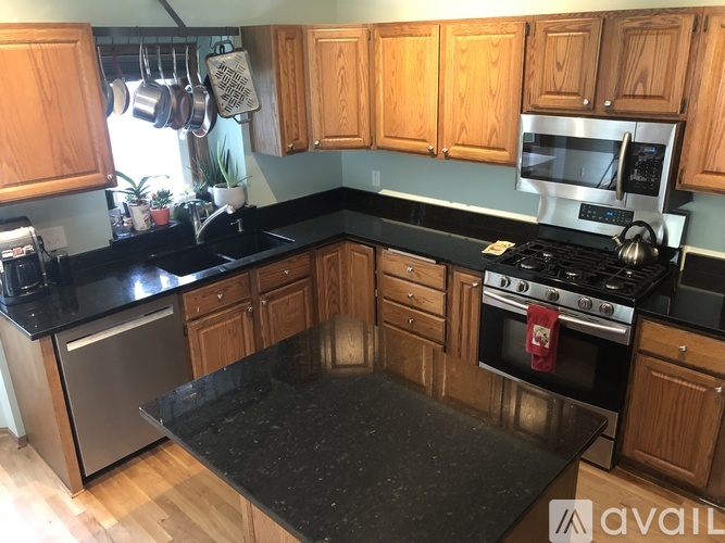 A kitchen with wooden cabinets and black countertops.
