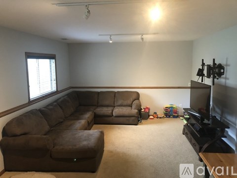 A living room with a brown couch and a television.