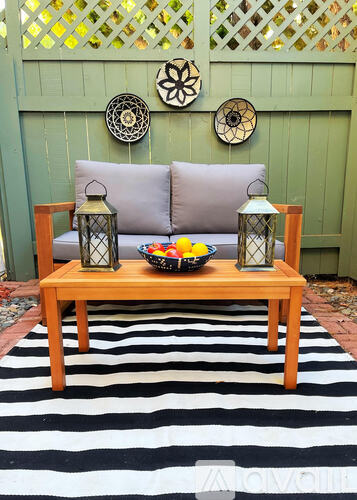 A wooden bench with a bowl of fruit and lanterns on it.