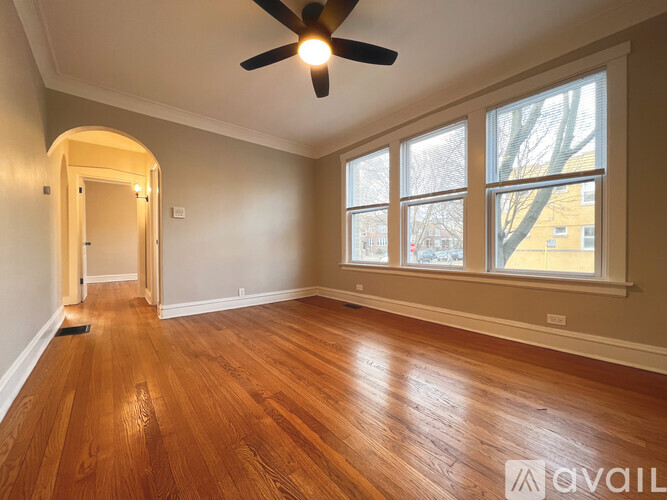 A room with a ceiling fan and wooden flooring.