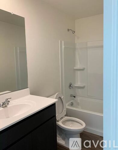A white toilet in a bathroom with a sink and mirror.