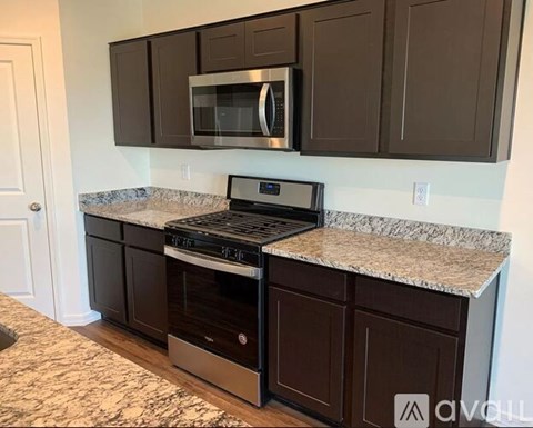 A kitchen with brown cabinets and a granite countertop.
