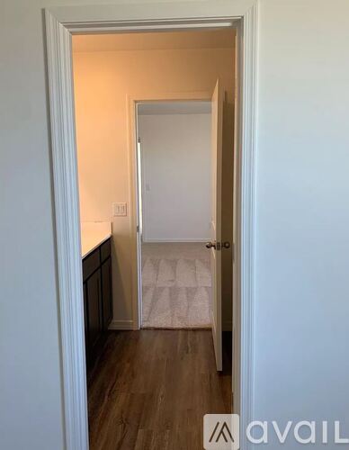 A hallway with a door on the right and a wall on the left.