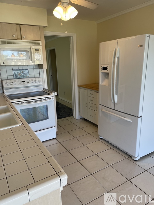 A kitchen with a white fridge and white oven.