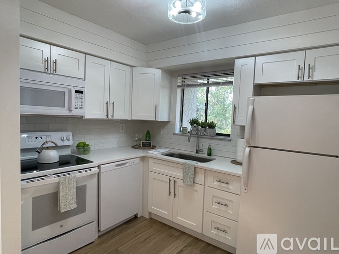 A kitchen with white appliances and cabinets.