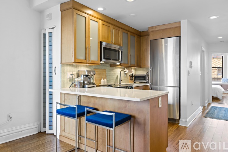 A kitchen with wooden cabinets and a stainless steel refrigerator.