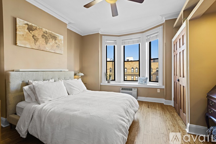 A bedroom with a large bed and a ceiling fan.