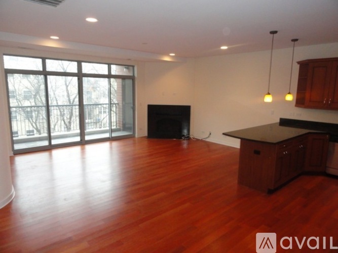 A living room with a fireplace and wooden floors.