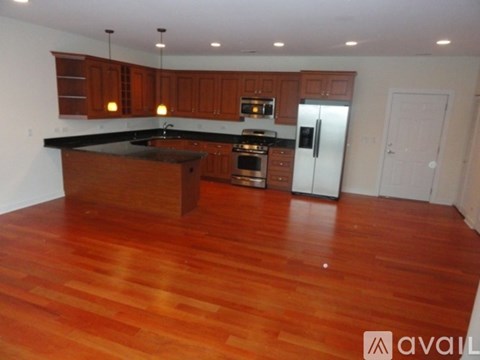 A kitchen with wooden cabinets and a black countertop.
