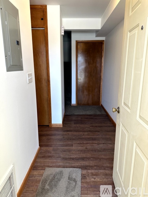 A hallway with a white door and a brown door.