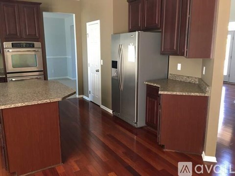 A kitchen with wooden cabinets and a granite countertop.