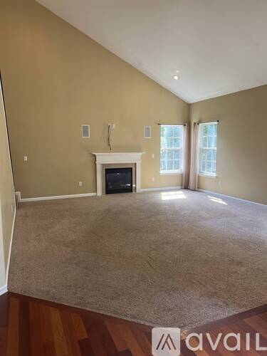 A living room with a fireplace and carpeted floor.