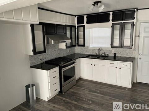 A kitchen with black countertops and white cabinets.