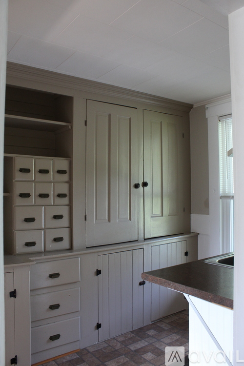 A kitchen with white cabinets and drawers.