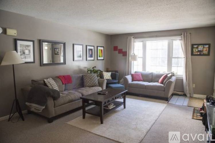 A living room with a grey couch, a coffee table, and a lamp.