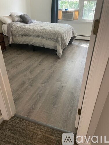 A bedroom with a bed and a carpeted floor.