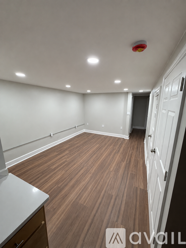 A room with wooden flooring and white walls.