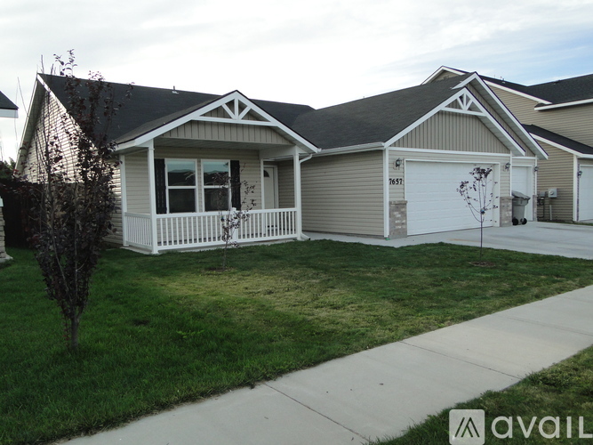 A house with a garage and a driveway in front.