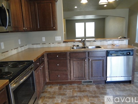 A kitchen with wooden cabinets and a tile floor.