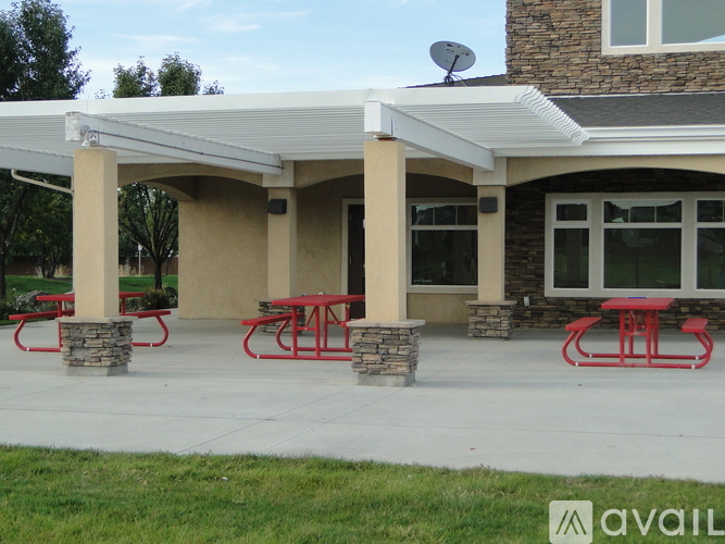 A covered picnic area with tables and a stone pillar.