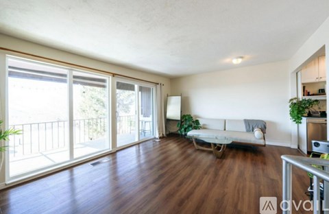 A living room with a white couch and a balcony with a railing.