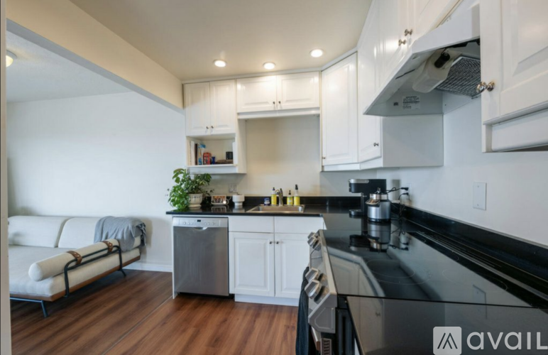A modern kitchen with a black countertop and white cabinets.