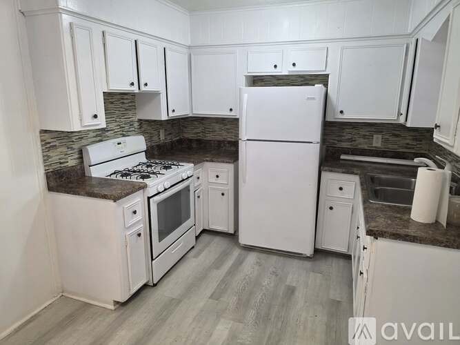 A kitchen with white appliances and cabinets.