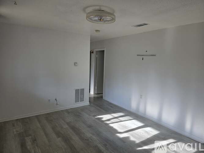 A room with a door and a window letting in sunlight.