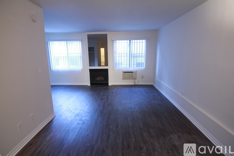 A room with wooden floors and two windows.