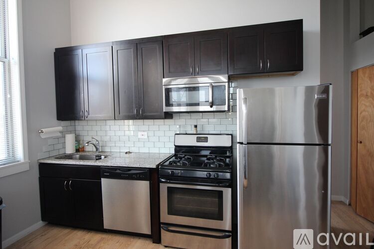 A kitchen with black cabinets and stainless steel appliances.