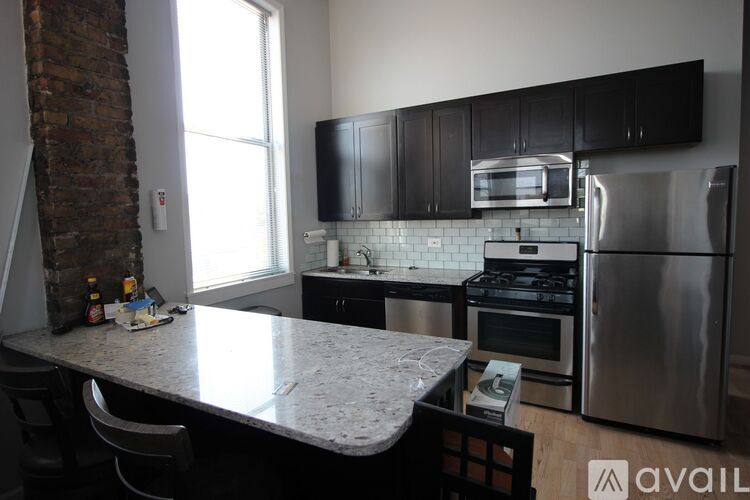 A kitchen with a granite countertop and stainless steel appliances.