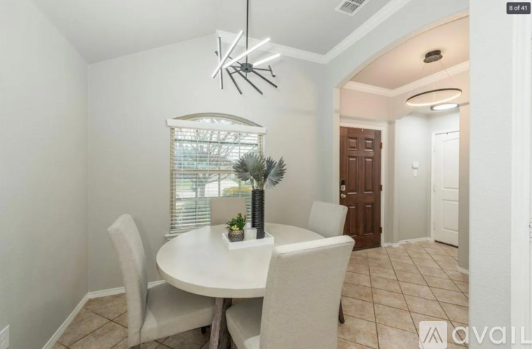 A dining room with a white table and chairs.