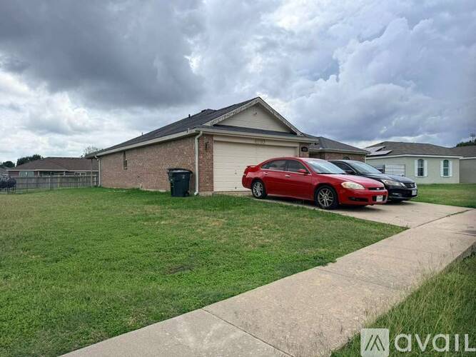 A red car is parked in front of a house.