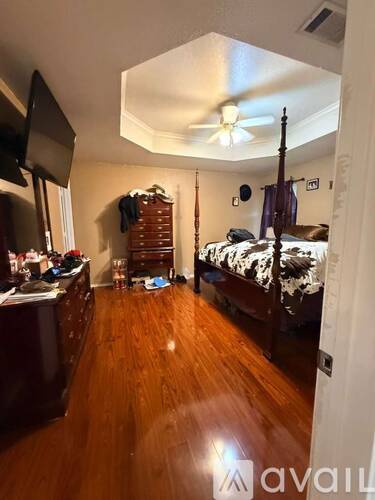 A bedroom with a bed, dresser, and mirror.